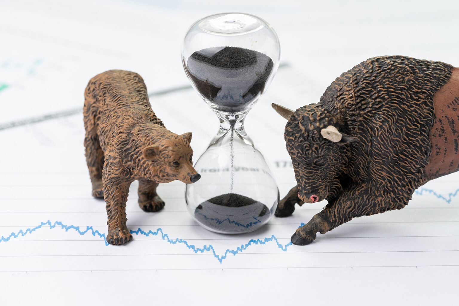 Time counting down to choose between investment bear and bull stock market concept, hourglass or sandglass on chart and graph, price list report paper surround by bear and bull figure