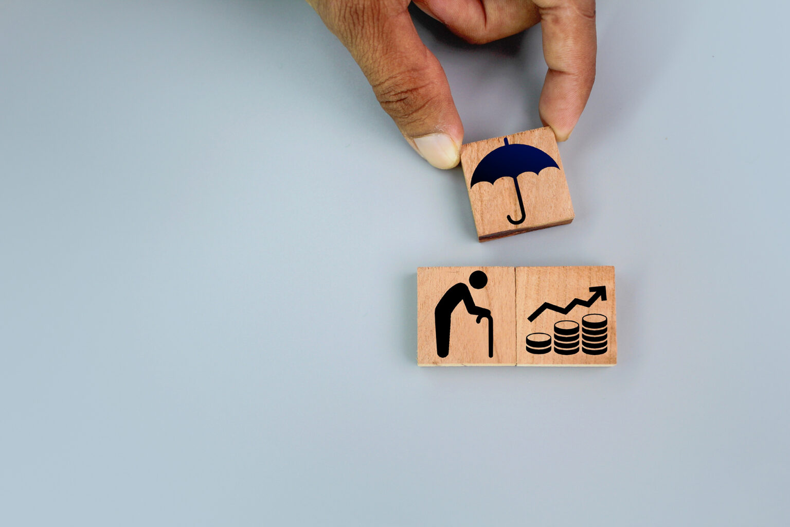 wooden square with icons of old man, save and umbrella or shelte