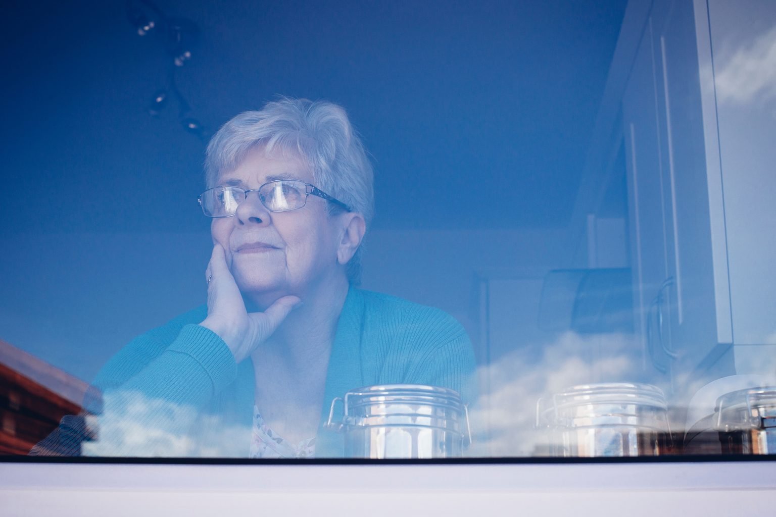 Senior woman looking out a window