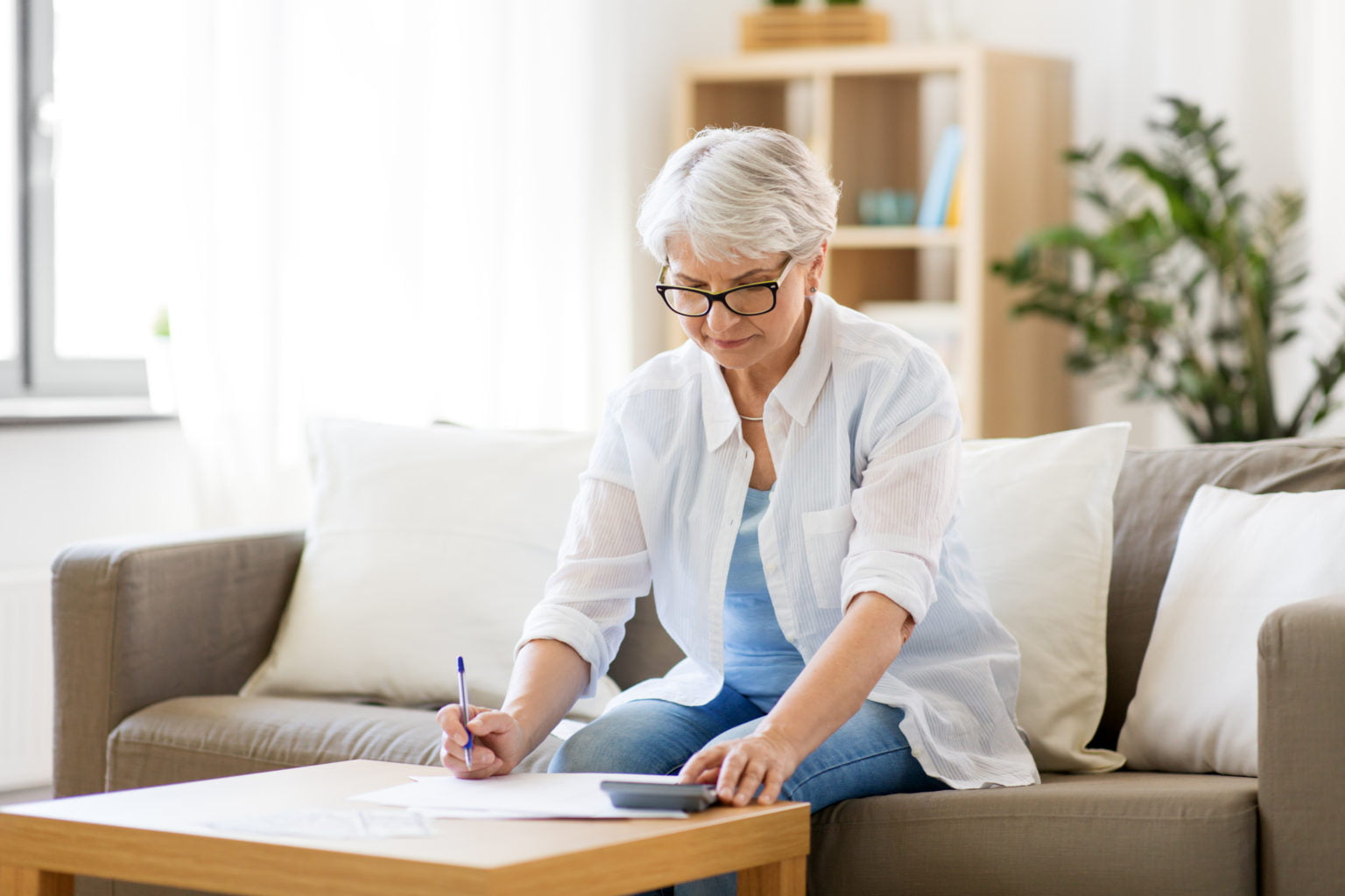 senior woman with papers or bills and calculator