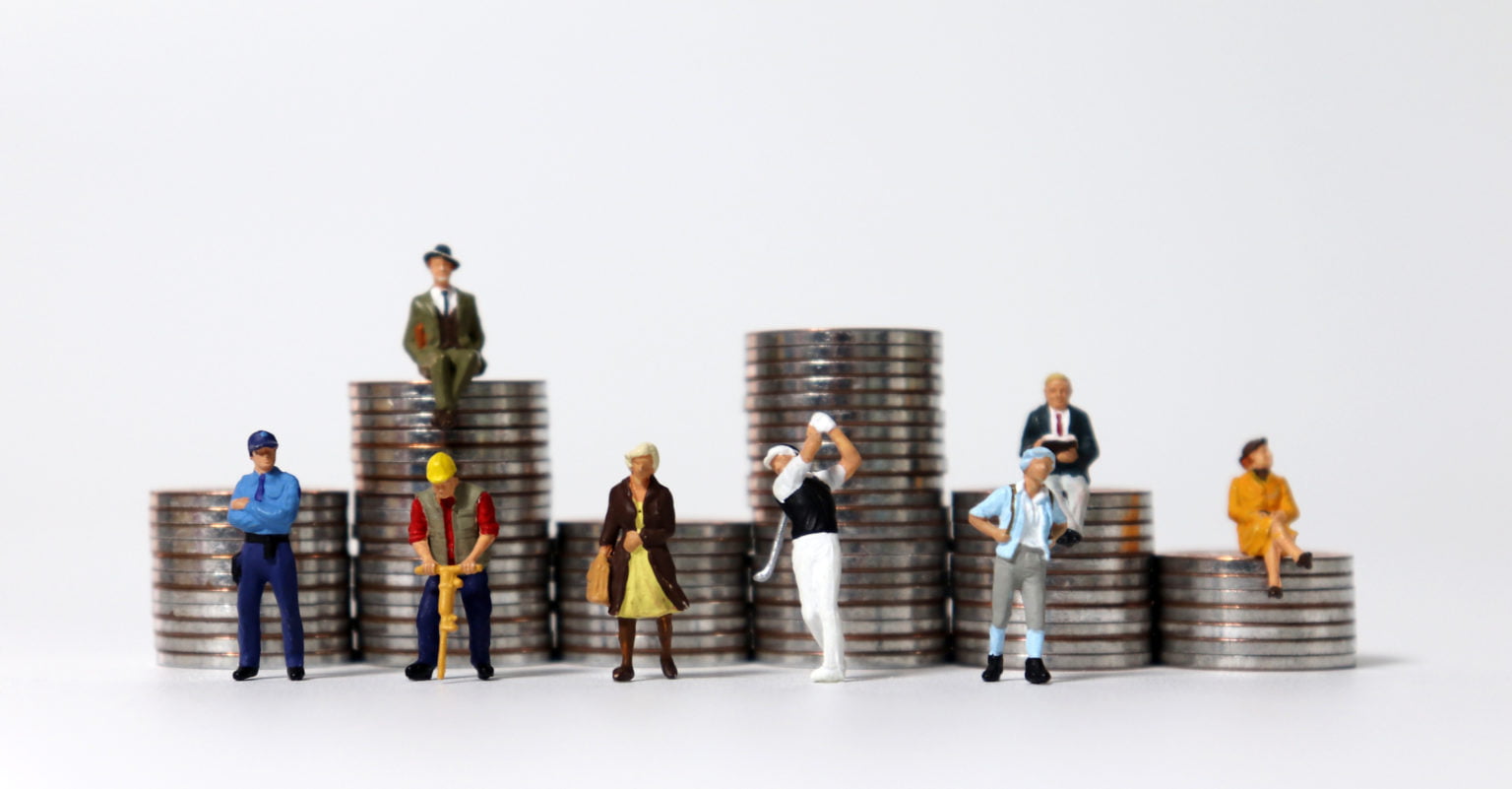 Minature people on different coin stacks