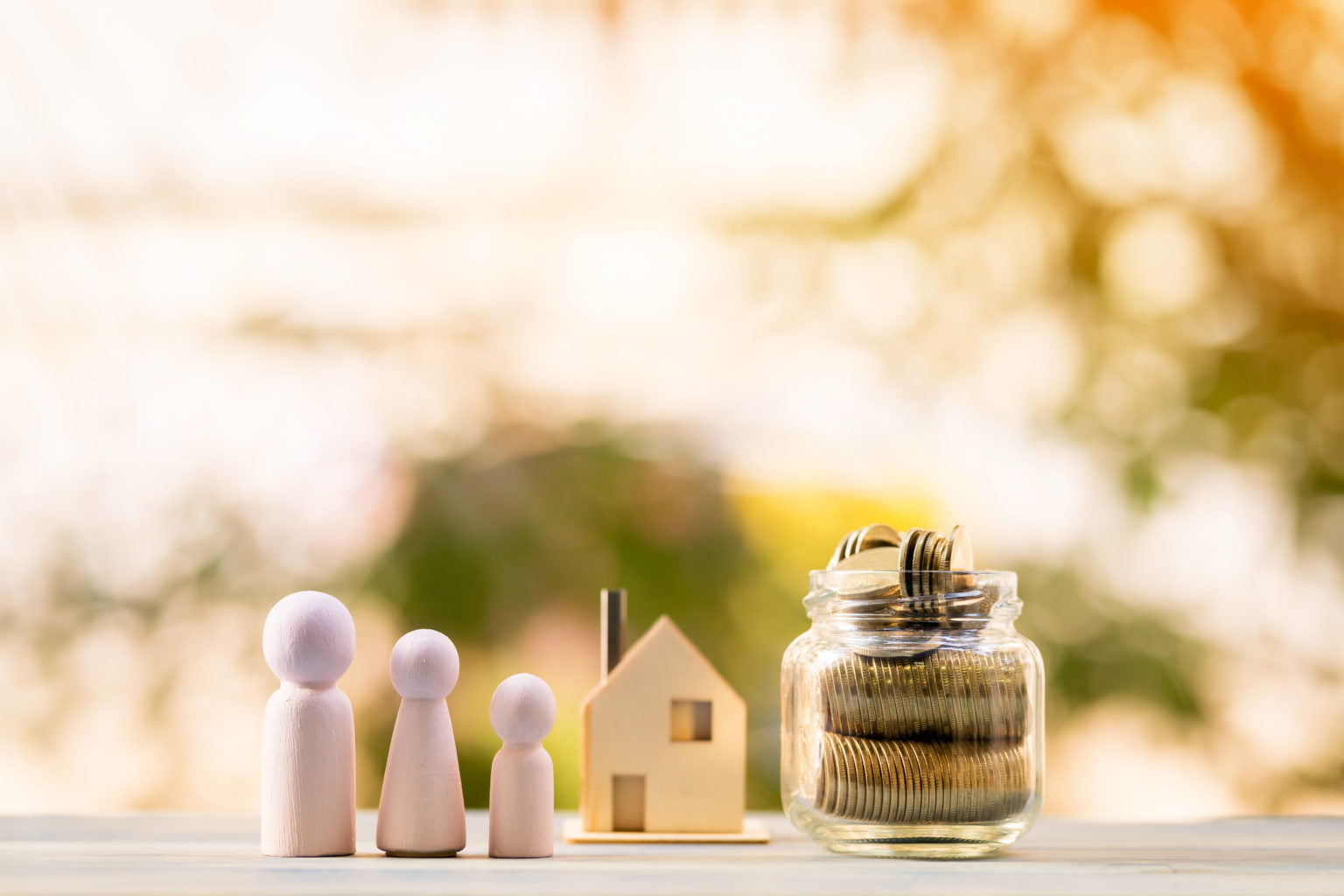 Three wooden figures with a house and coins