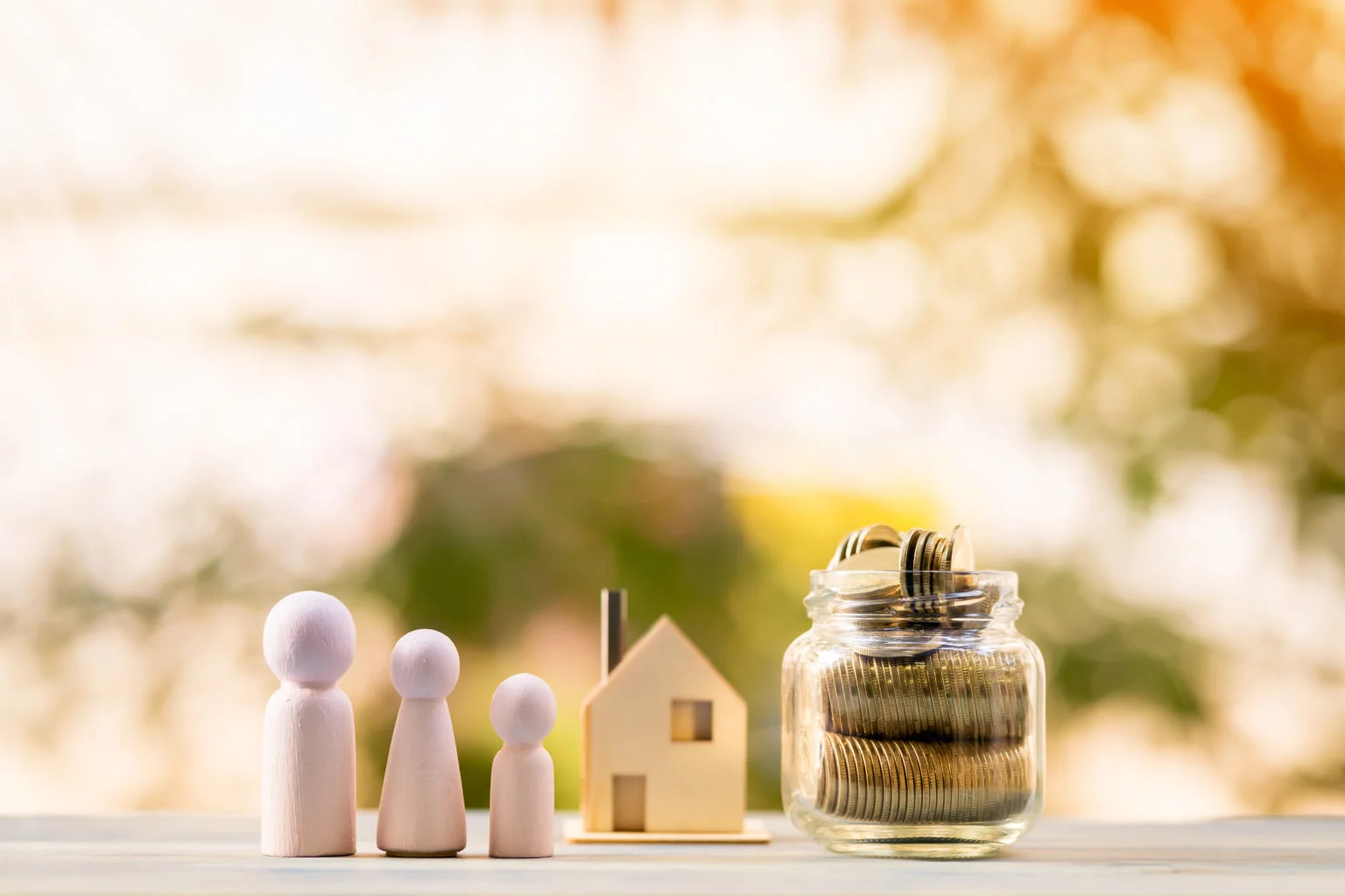 Three wooden figures with a house and coins