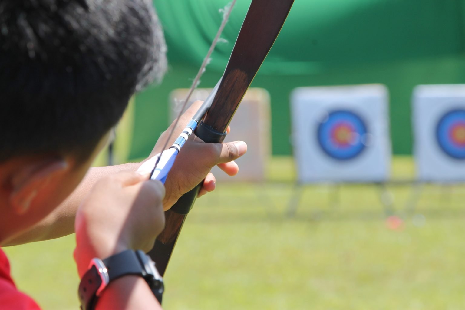 target ring and out of focus archer with a bow in the foreground during an archery competition