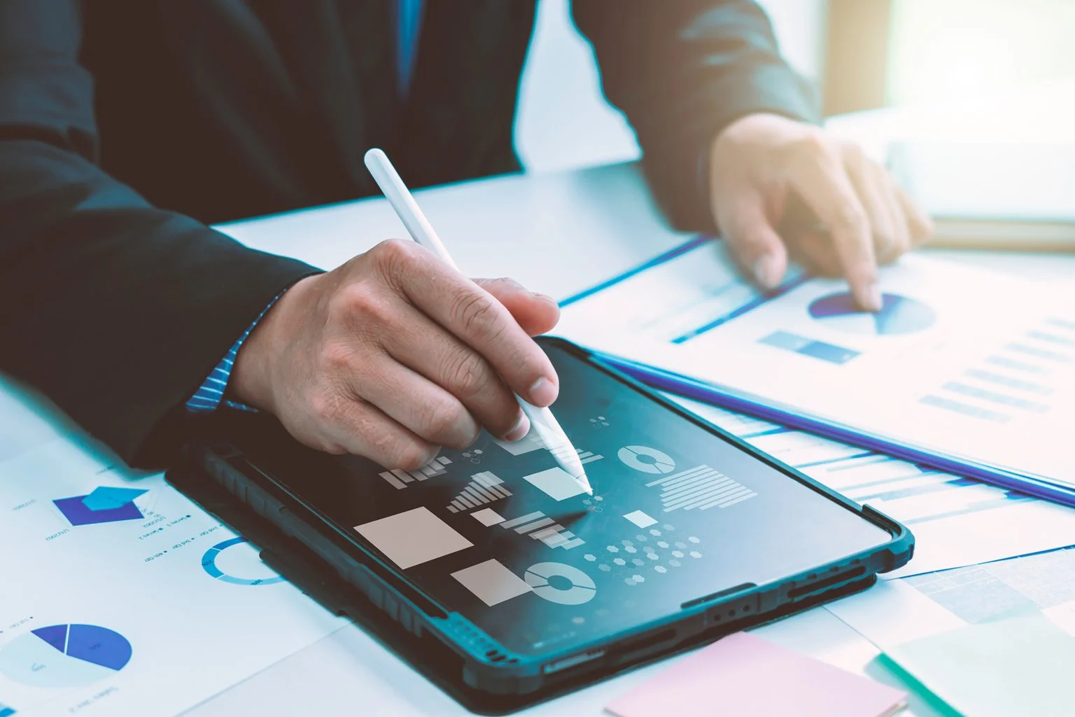 businessman using tablet with laptop and document on desk in modern office with virtual interface graphic icons network diagram