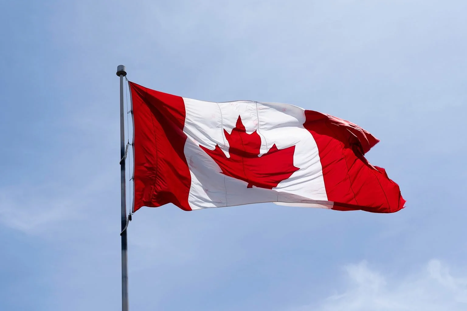 Waving Canadian flag with blue sky in background