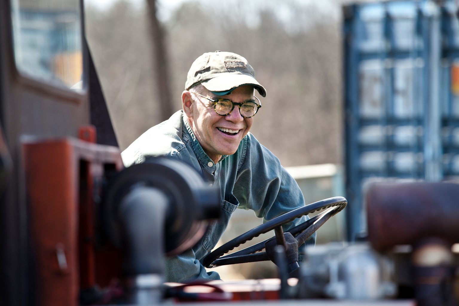 Senior man laughing while sitting in forklift