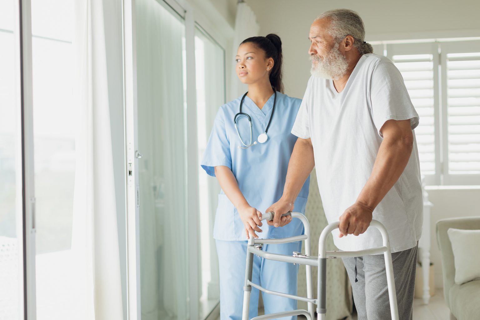 Healthcare worker with man using walking support