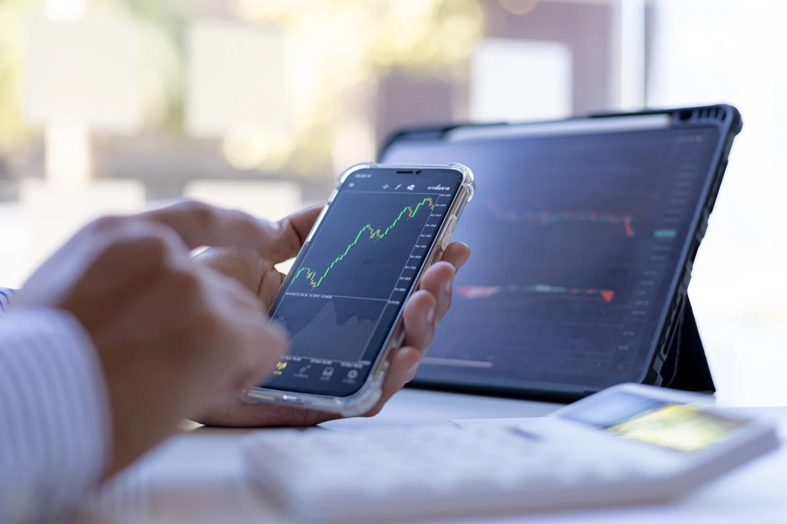 An investor is looking at stock charts on mobile phone