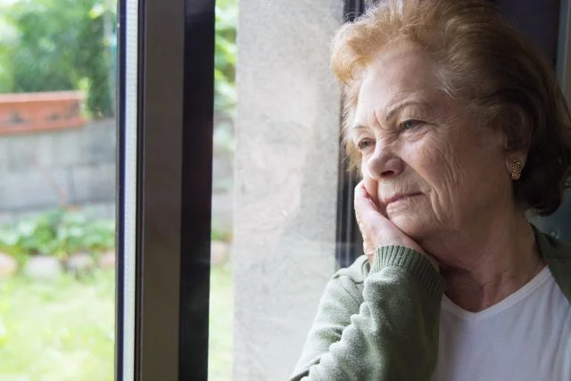 older woman looking out the window