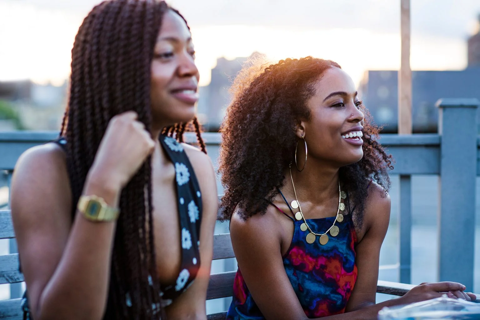 Smiling young women sitting outdoors