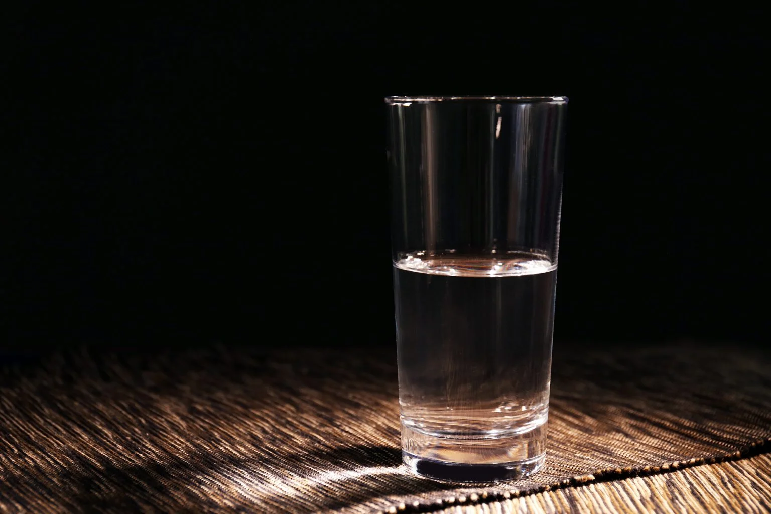 Half full glass of water on a table
