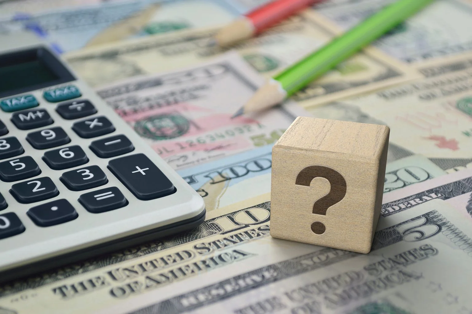Question mark sign flat icon on wooden block cube with calculator and pencil on dollar bank note