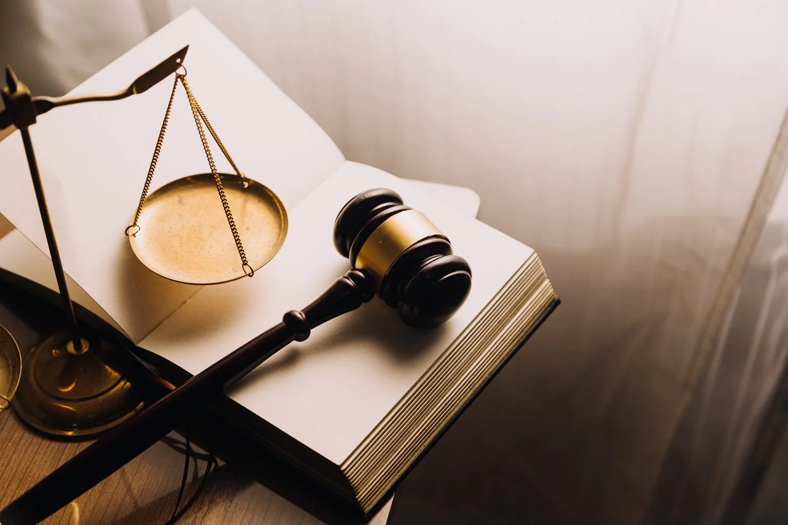 Gavel on an open book with justice scales justice