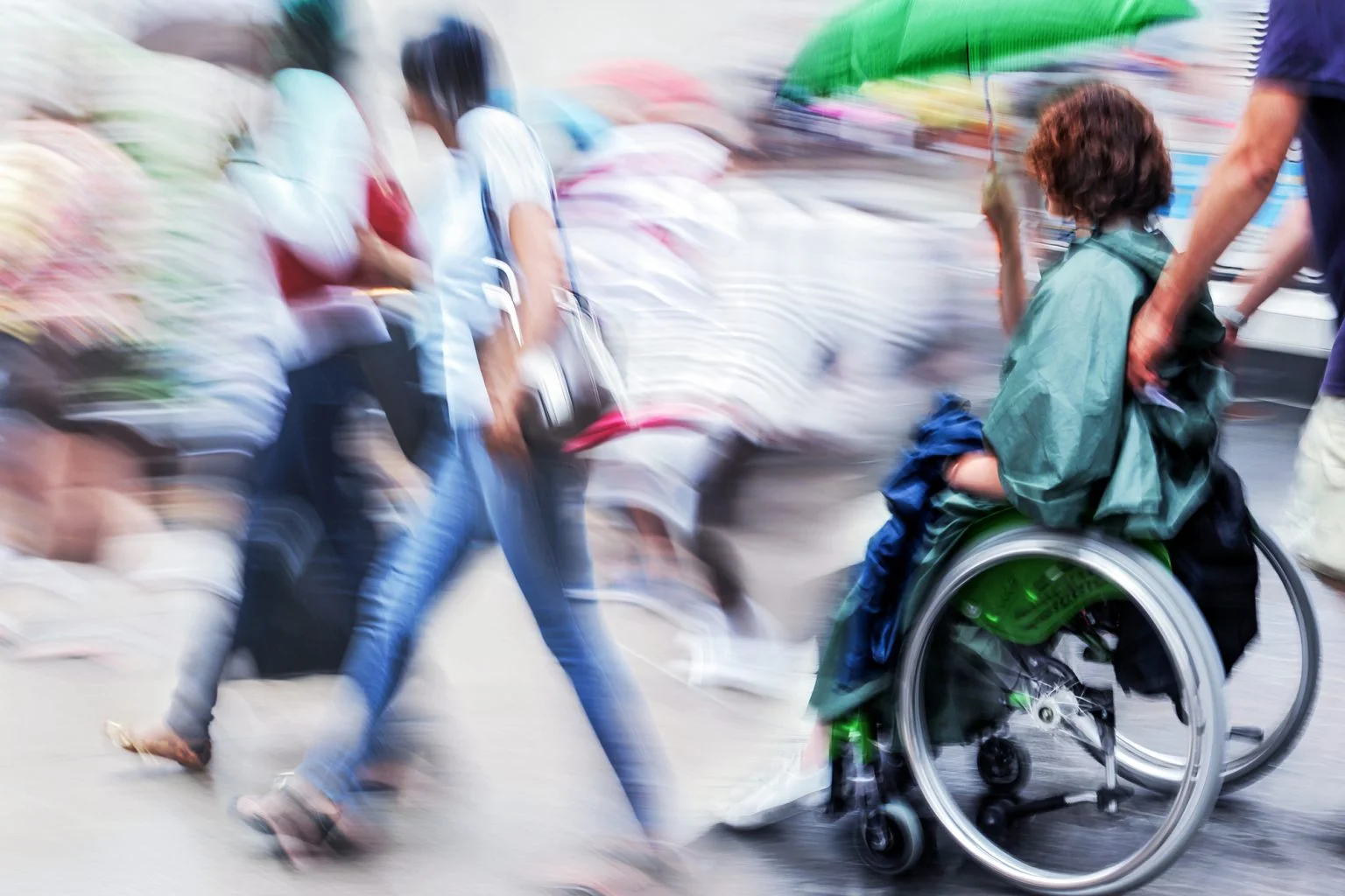 People walking and one in a wheelchair on a city street