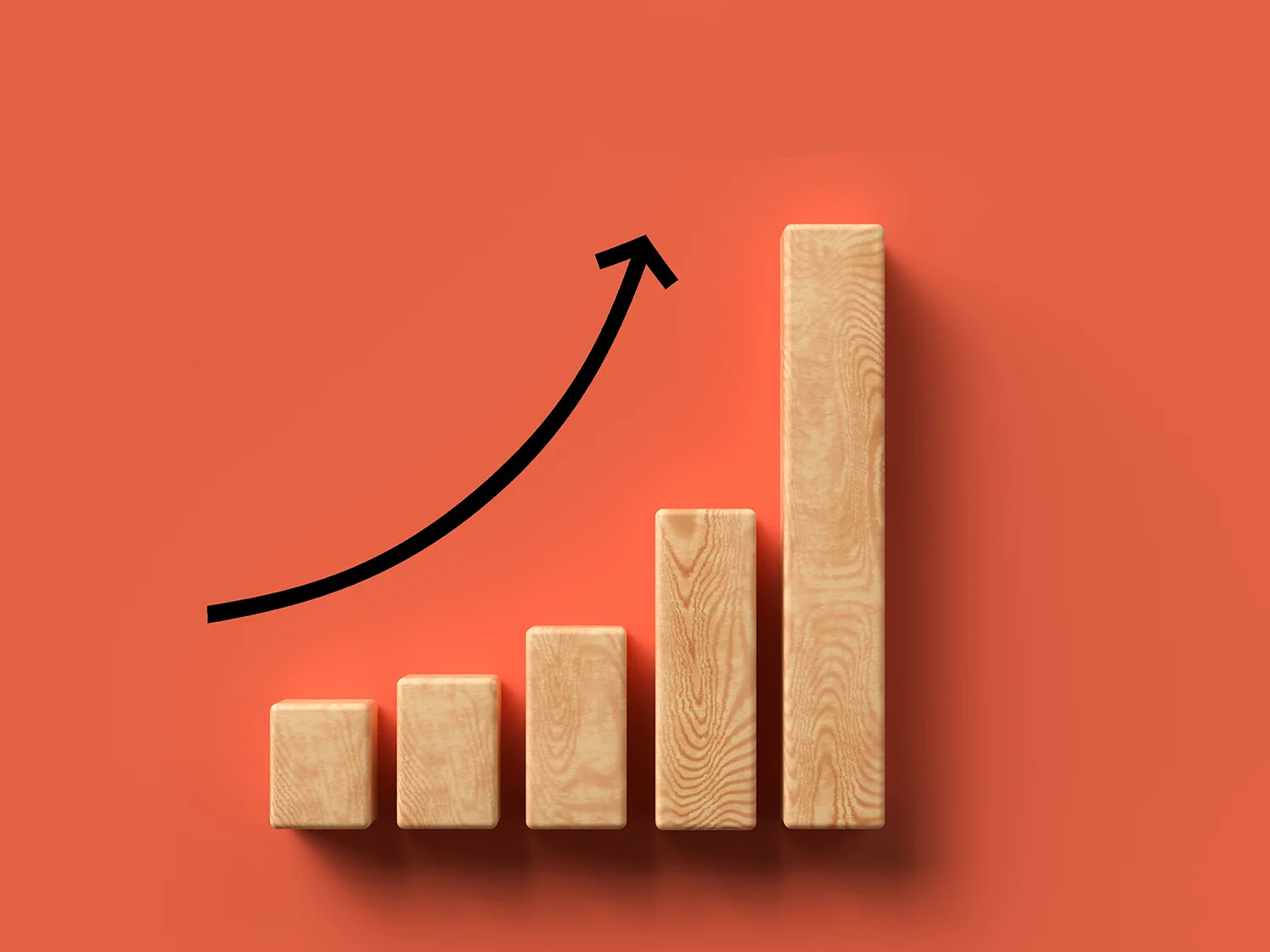 wooden blocks showing a growing graph with an arrowing pointing up on a coral background