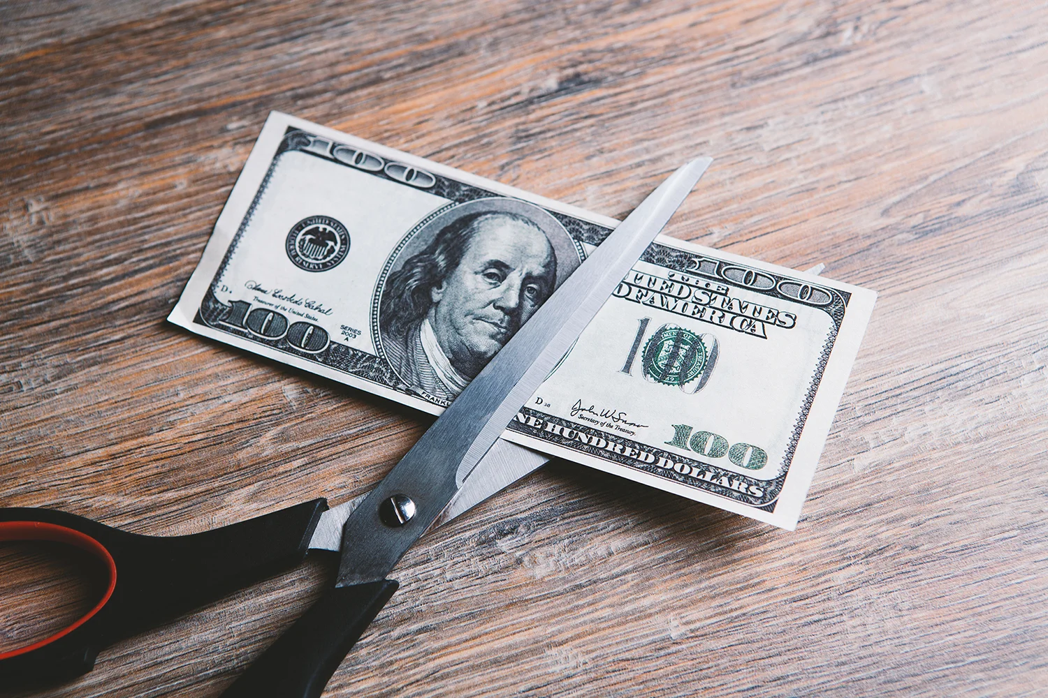 Scissors cut a dollar bill in half