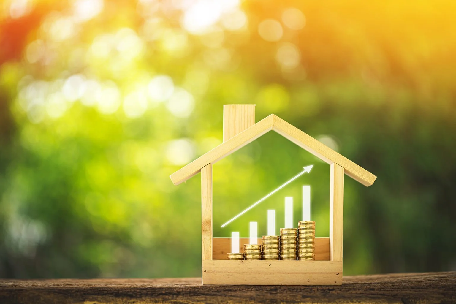 Stacking gold coins with growing interest value put in a wooden home model and bar and arrow graph