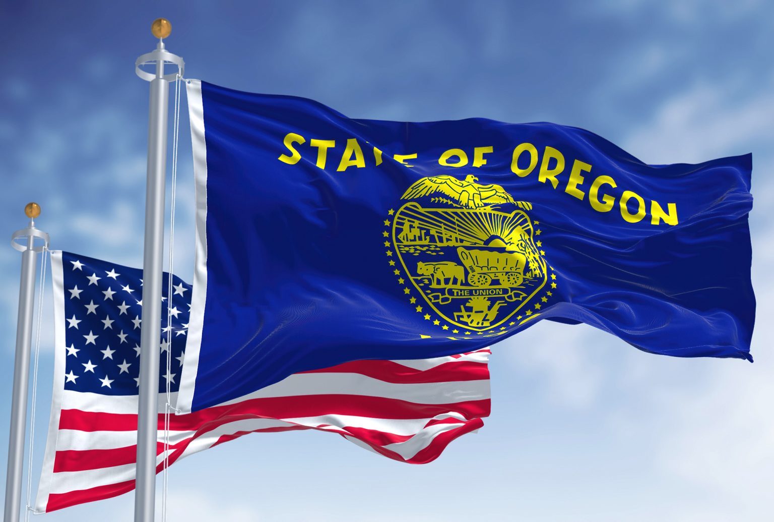 The Oregon state flag waving along with the national flag of the United States of America