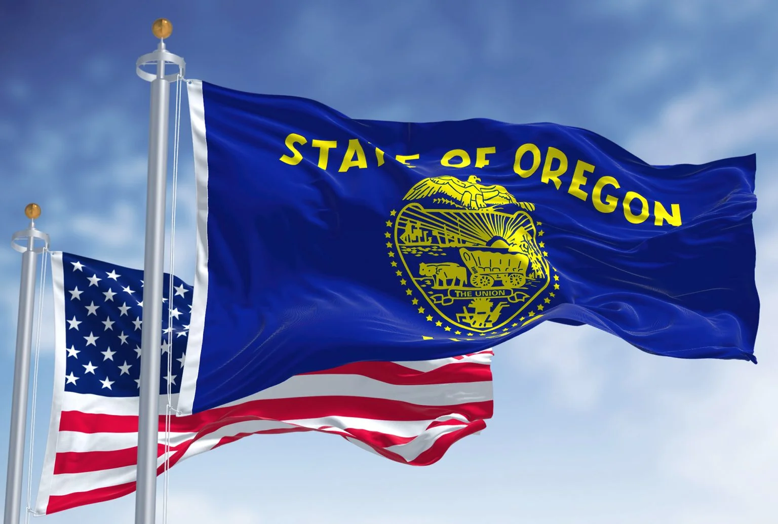 The Oregon state flag waving along with the national flag of the United States of America