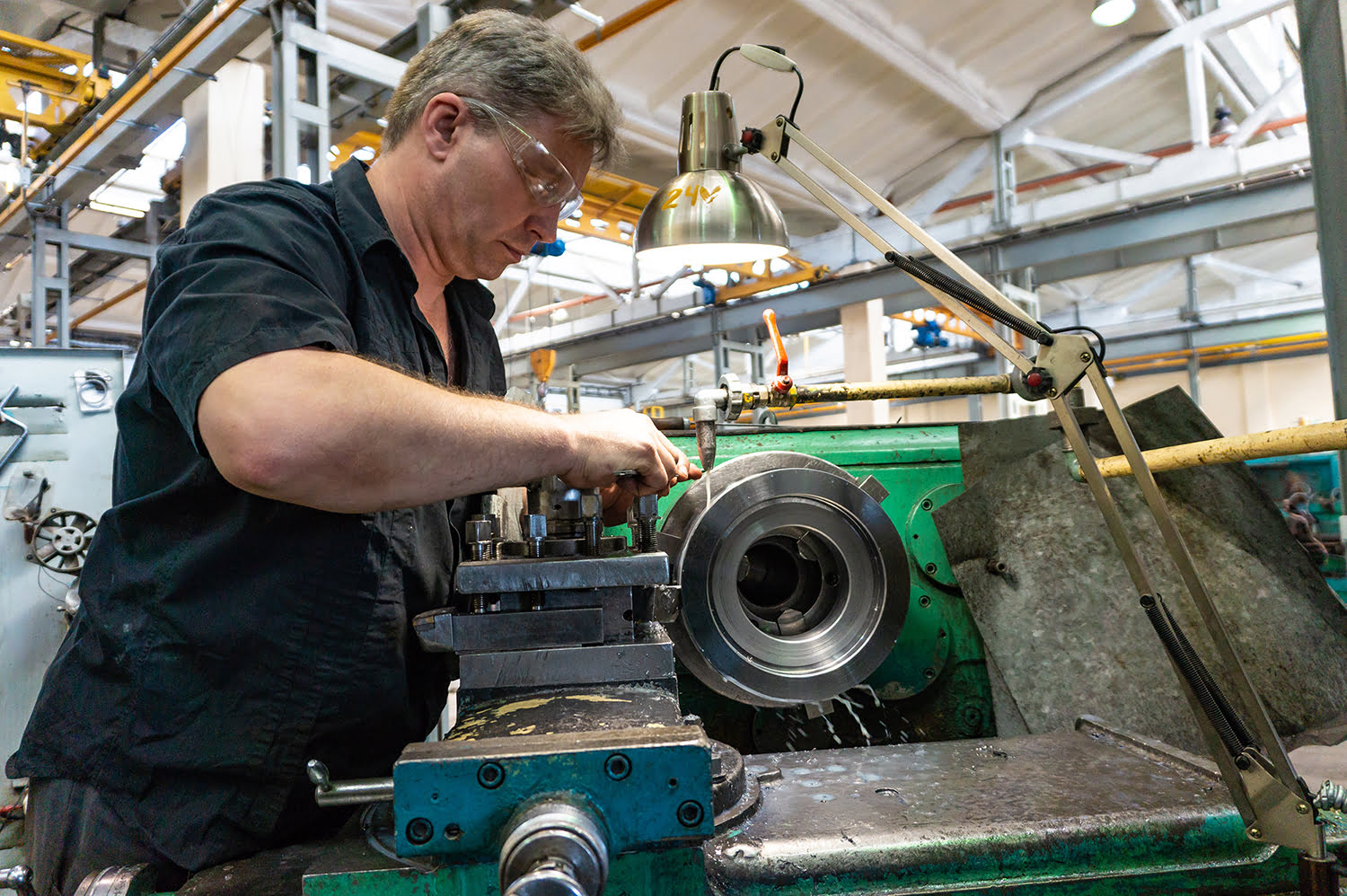 a man in a black shirt and goggles, controls a mechanical machine