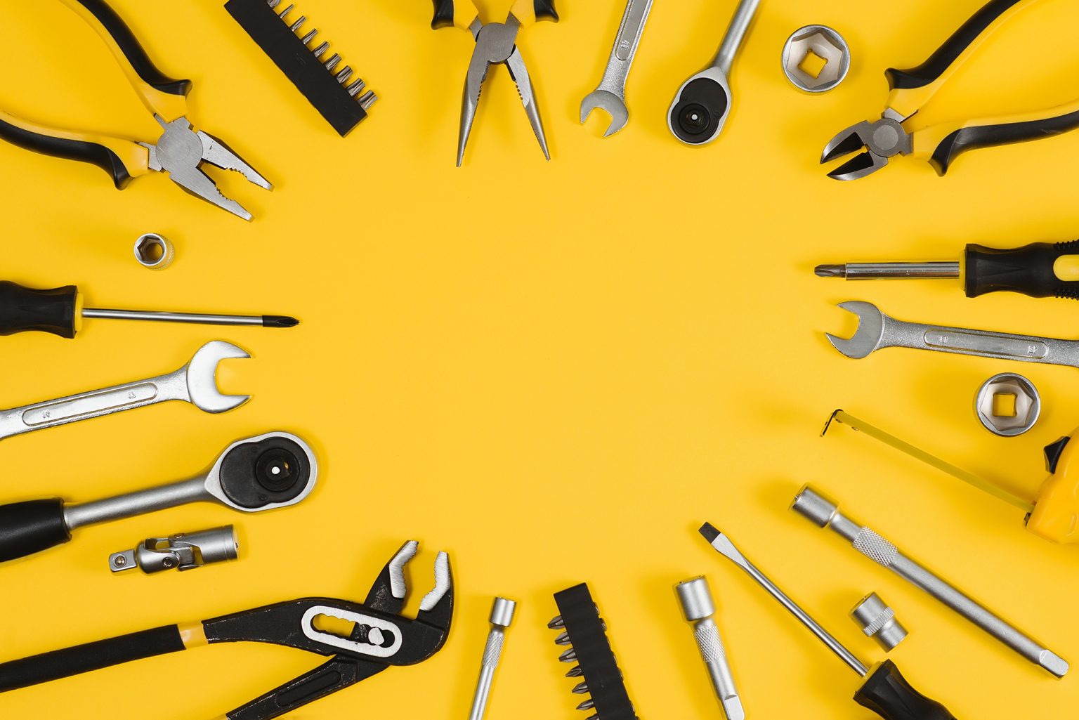 Set of various construction tools on a yellow background
