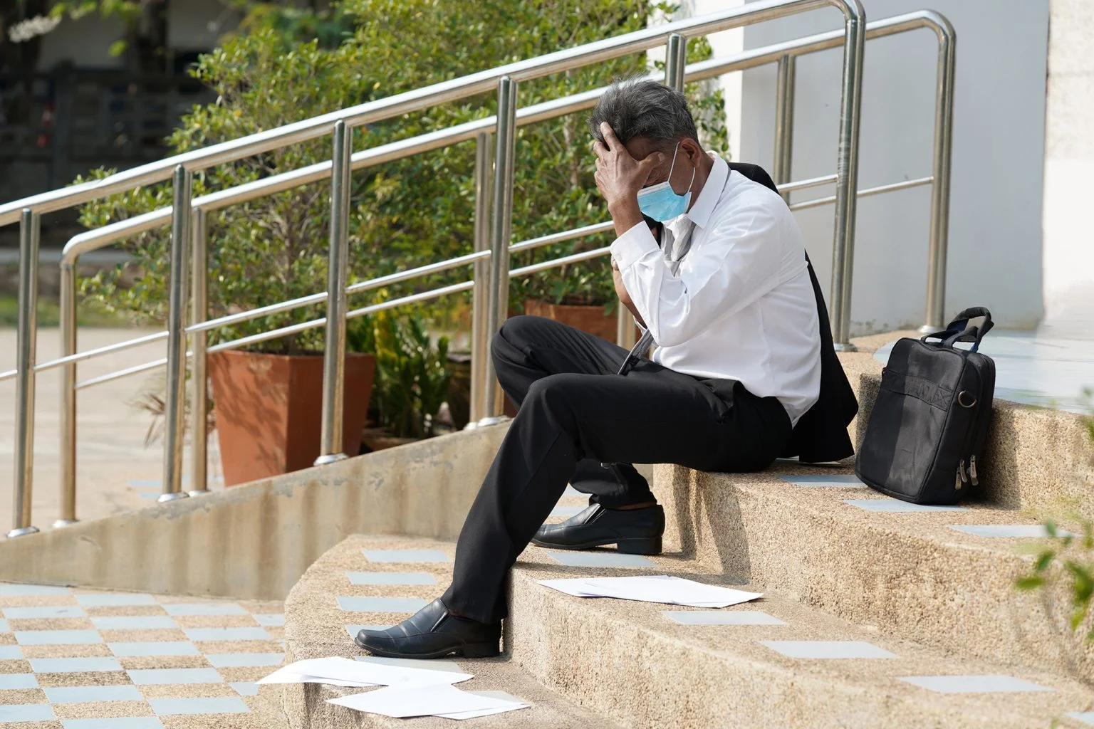Businessmna with his head in his hands on steps