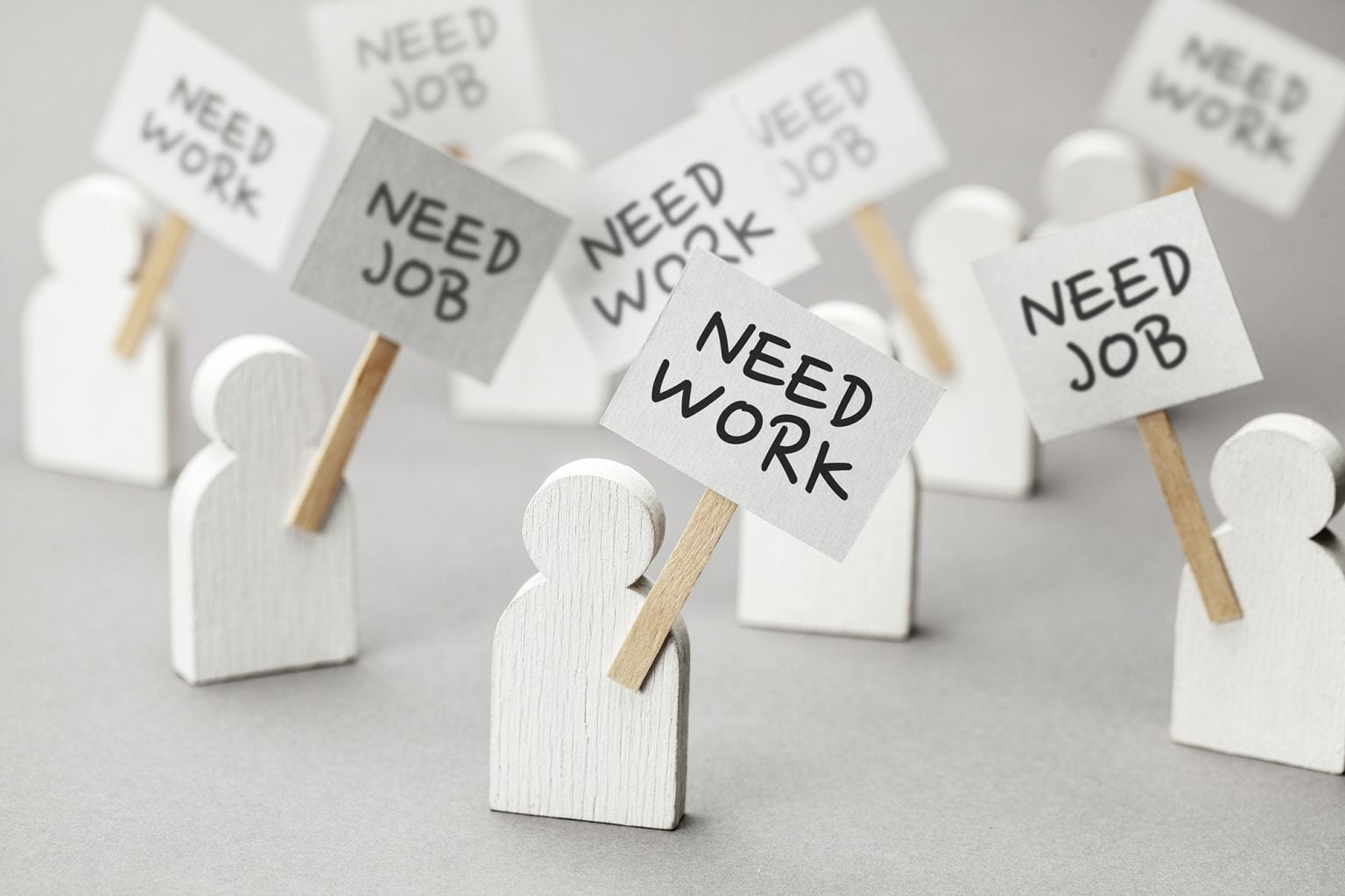 Crowd of unemployed people with posters on gray background
