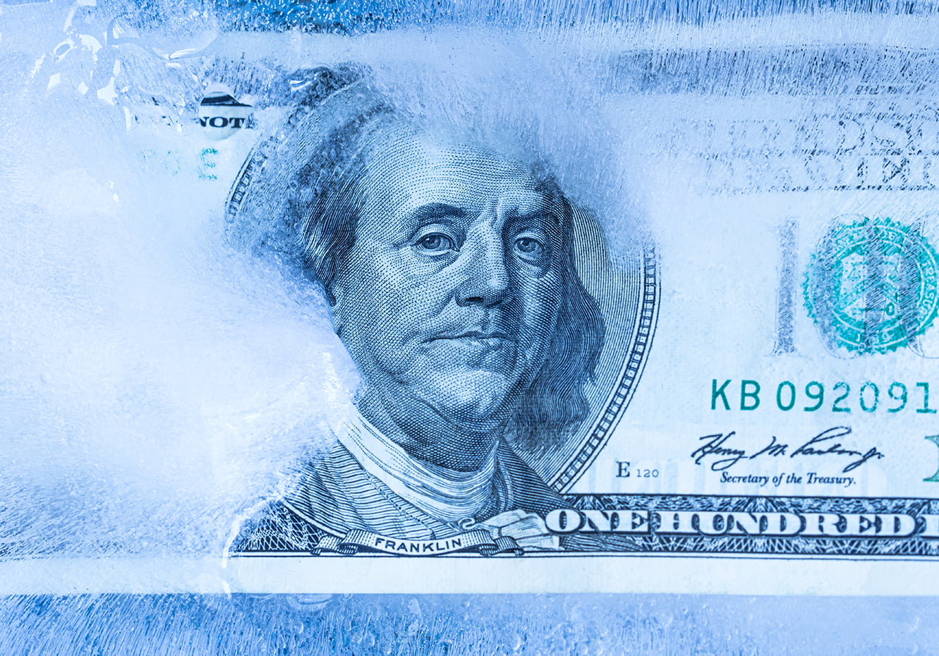 100 US dollar frozen under a layer of ice