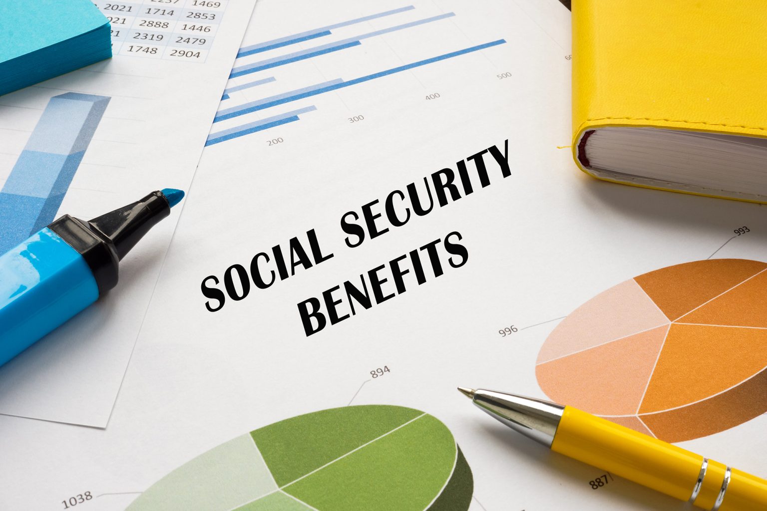 Social Security benefits on a page with charts and a pen and highlighter
