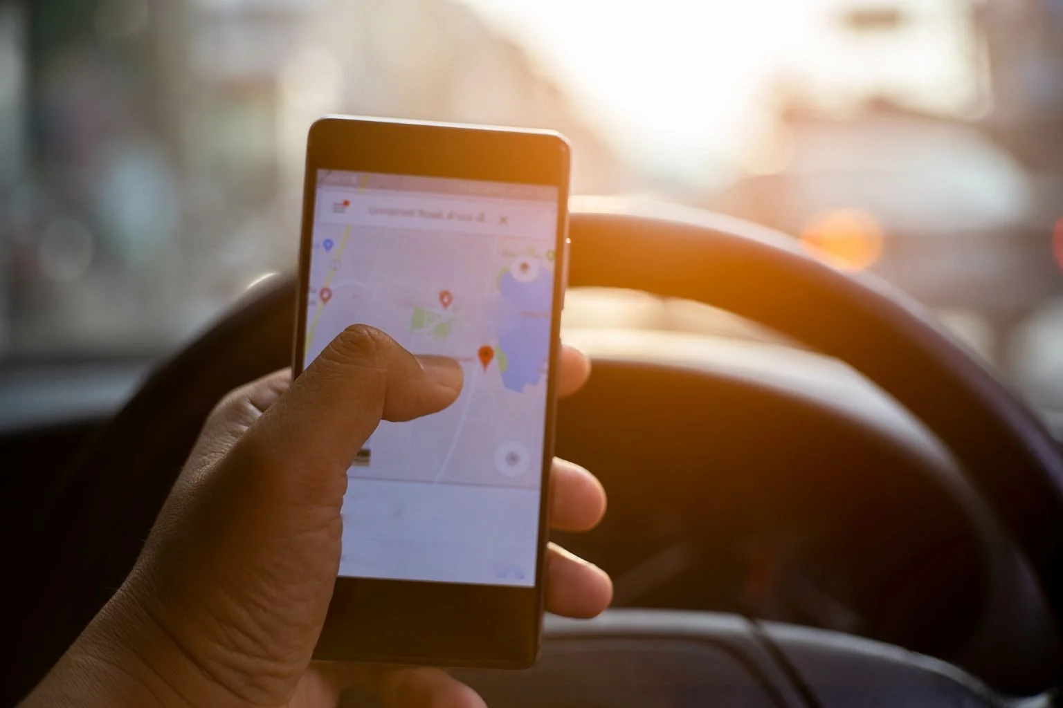 Driver holding smartphone with gps app interface for search position