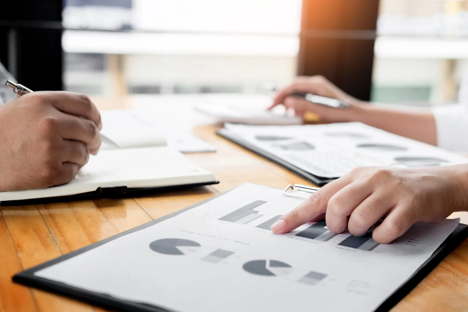 Business people looking at graphs on a clipboard