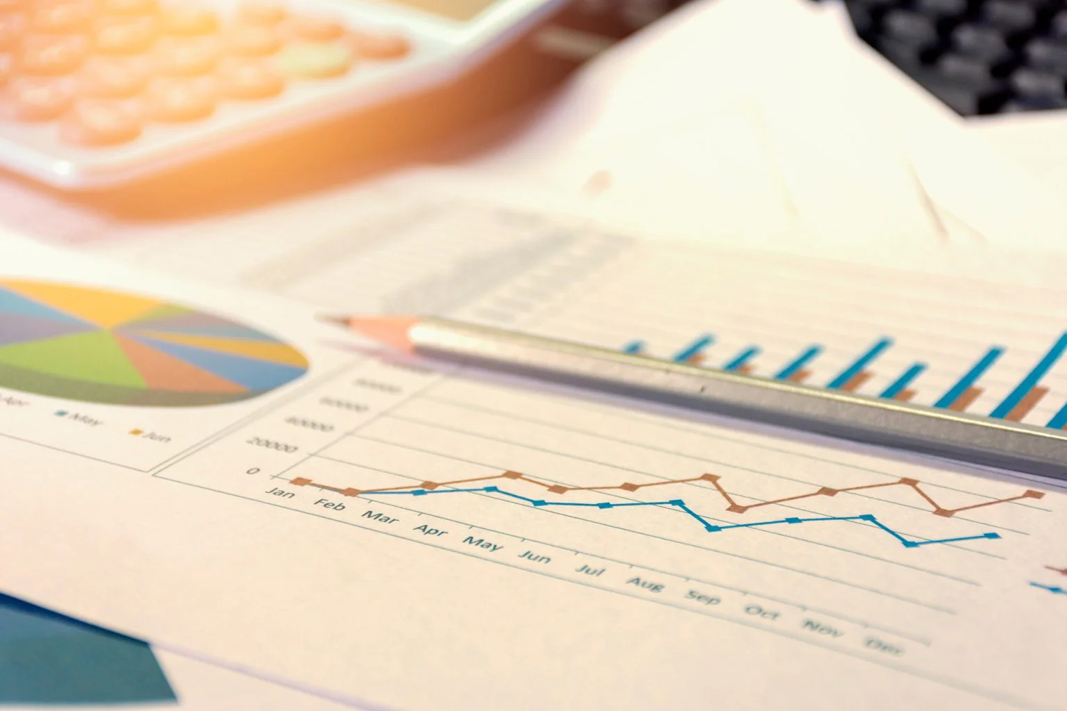 Financial graphs on a paper with a pencil and a calculator
