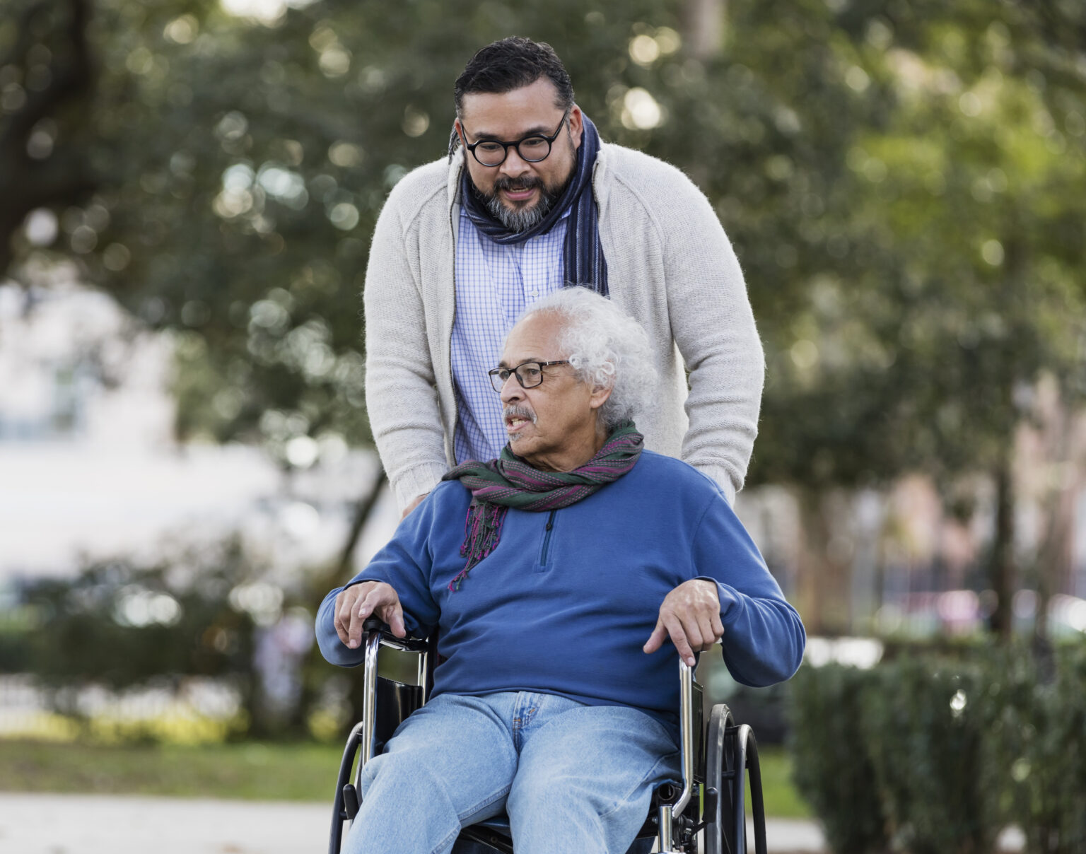 Senior Hispanic man in wheelchair, with adult son