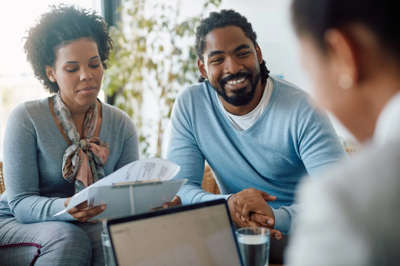couple goes through paperwork while being on meeting with financial advisor