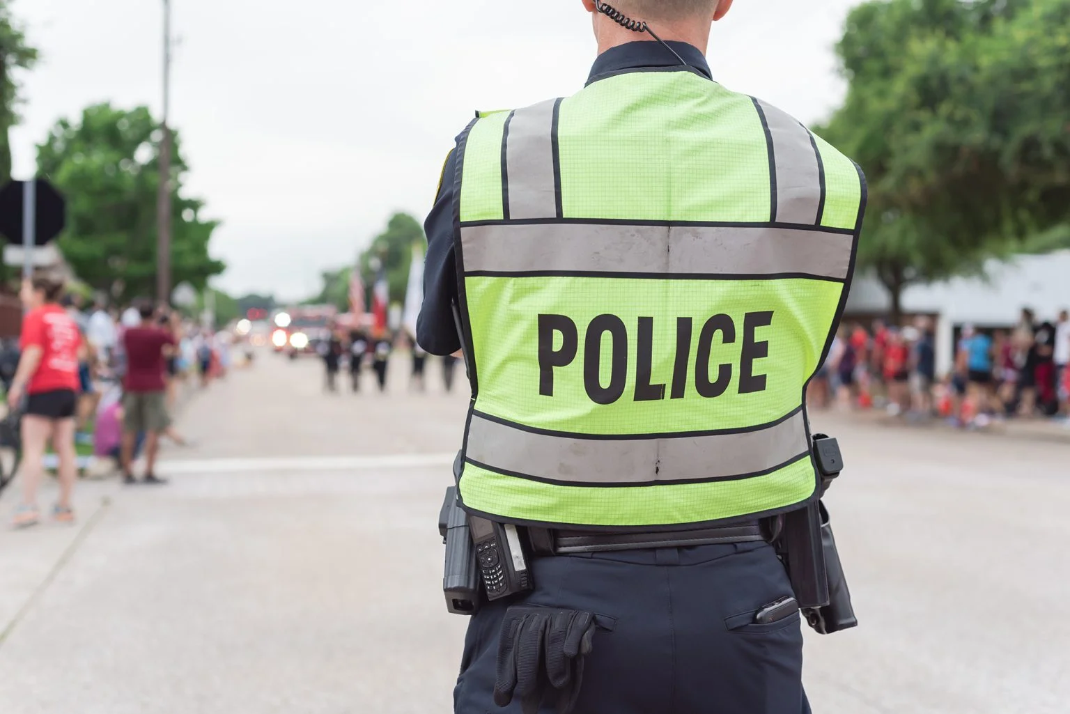 Close-up rear view police officer at public July 4 parade street