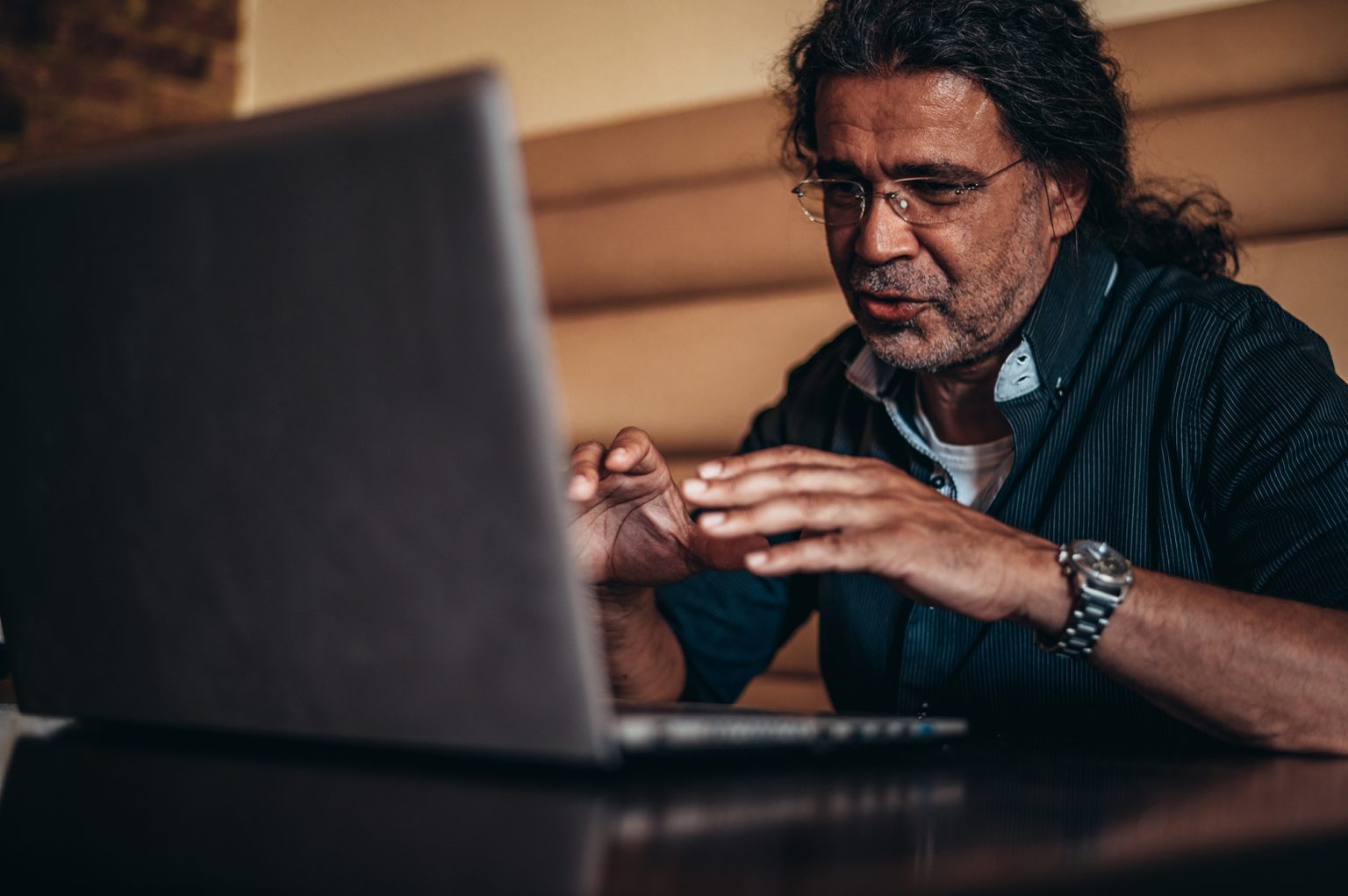 Senior men using laptop while working remotely