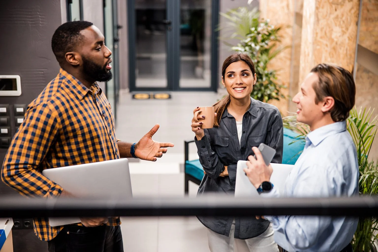 3 young co-workers chatting on a balcony