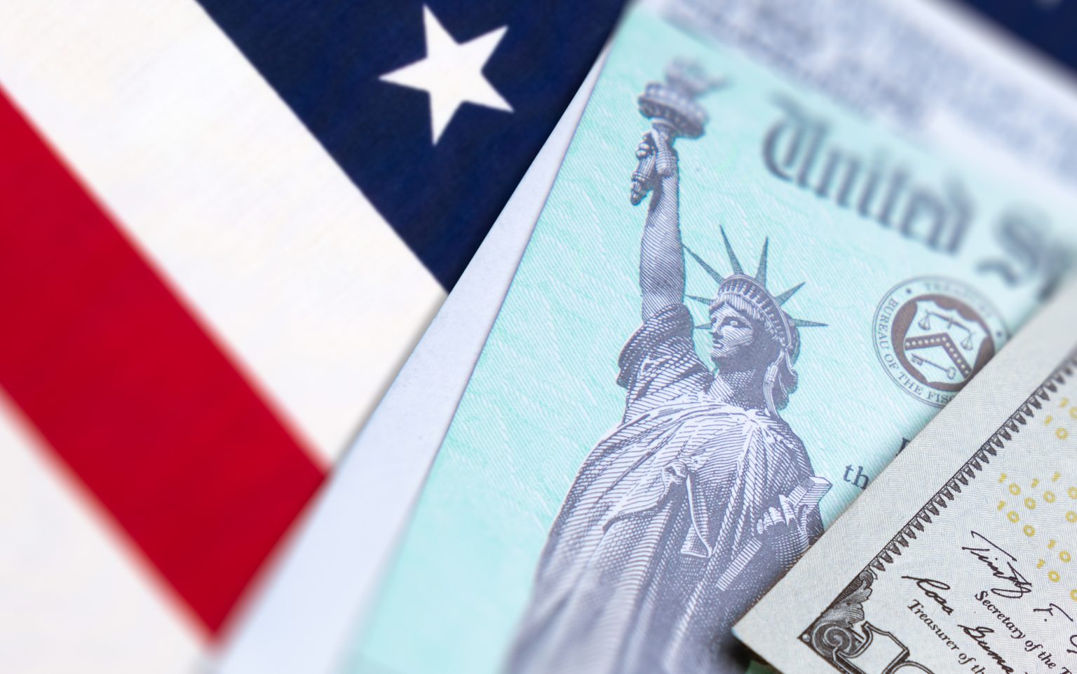 United States IRS Check, Envelope and Money Resting on American Flag