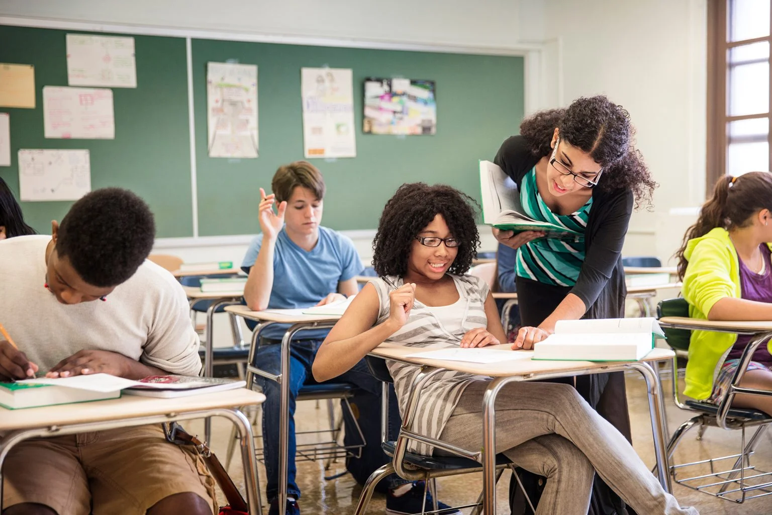 Teacher helping student in classroom