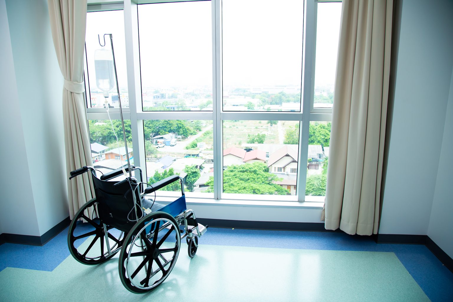 Empty wheelchair stand near window at hospital