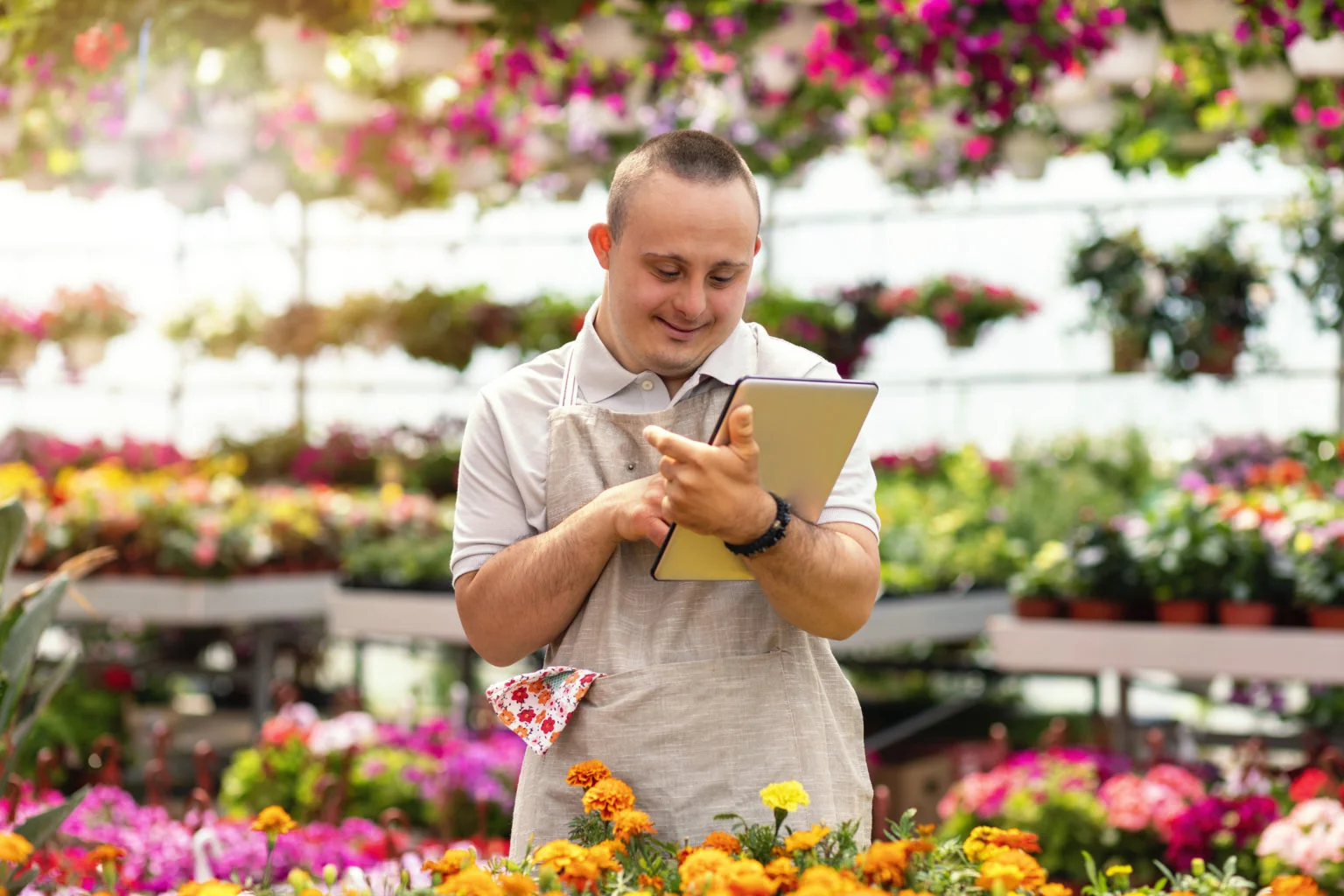 Social inclusion – man with down syndrome working in garden center