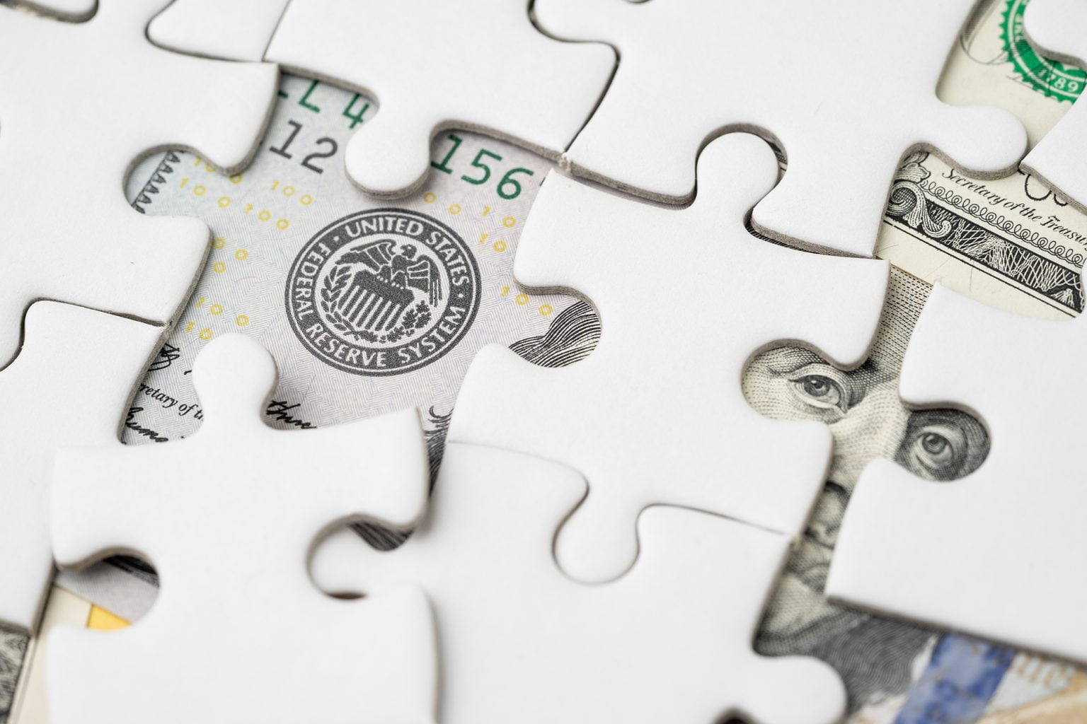 puzzle pieces reveals U.S. currency underneath