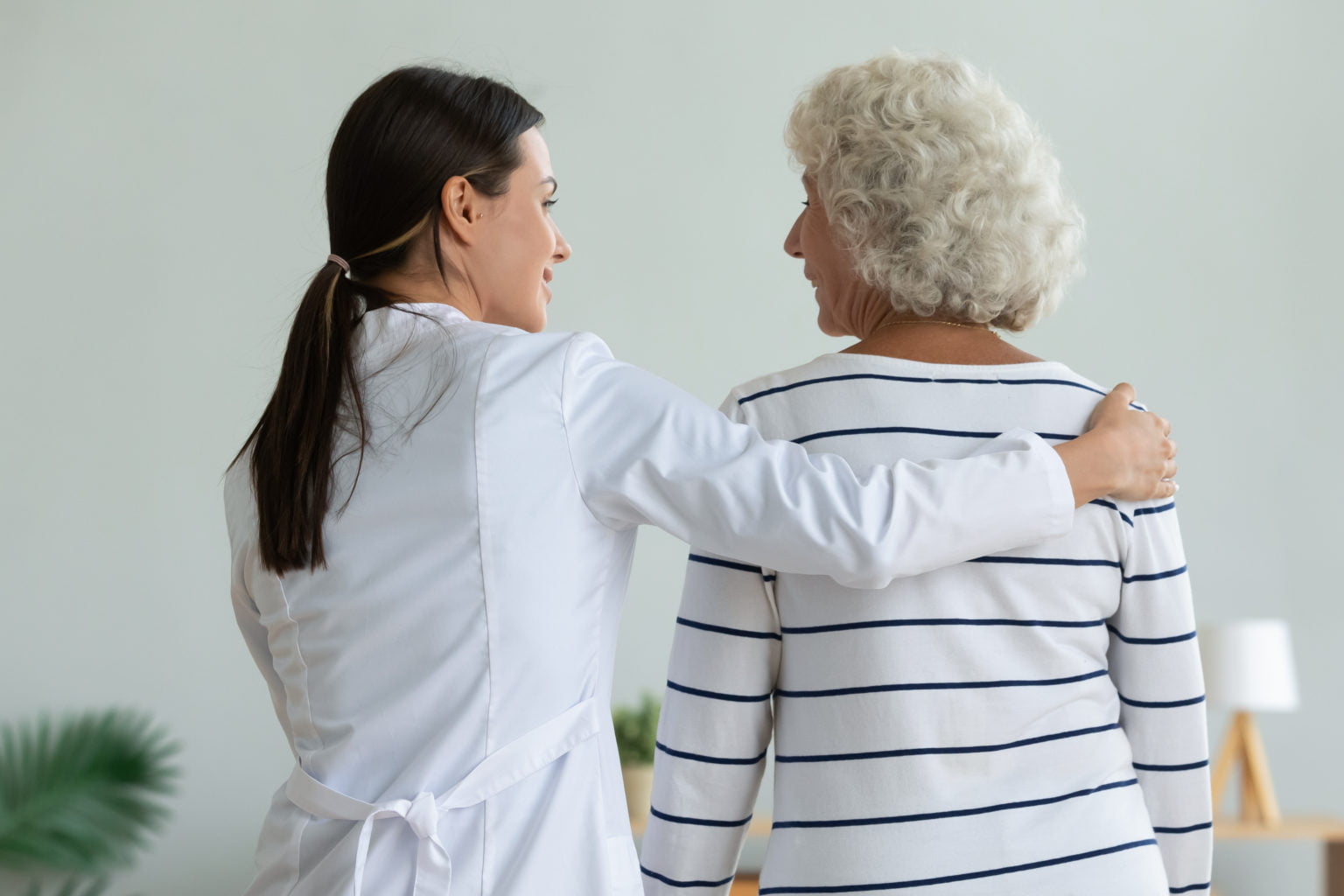 Rear,Back,View,Of,Young,Female,Doctor,Physiotherapist,Caretaker,Help