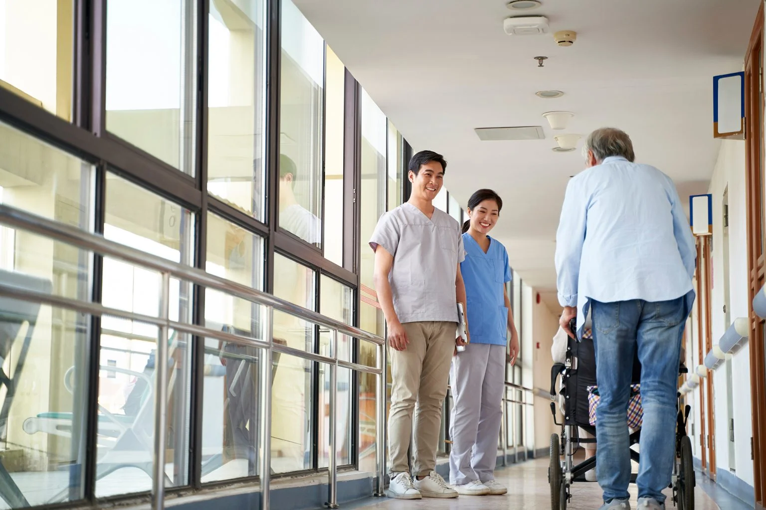 nurses greeting residents in hallway of nursing home