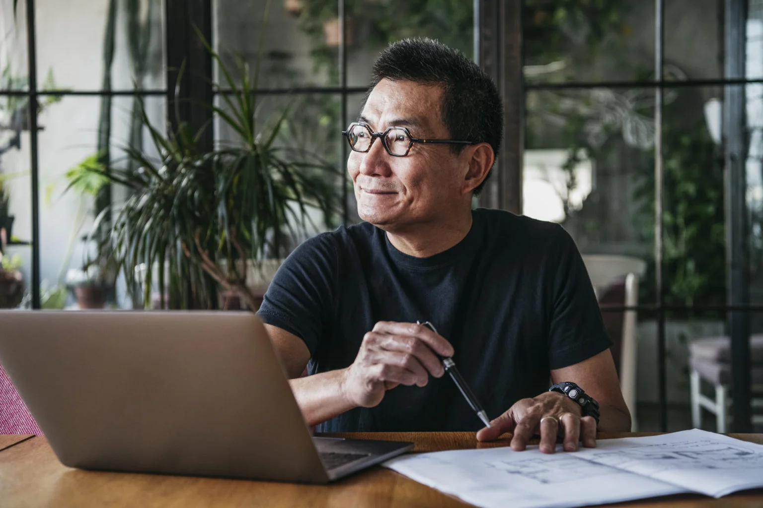 Mature Chinese man using laptop at home