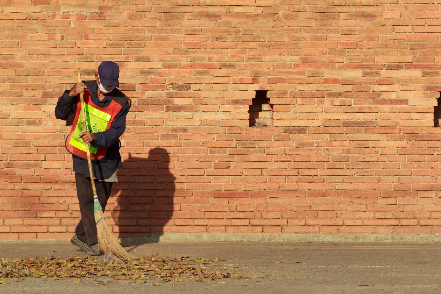 Scavenger,(local,Government,Staff),Sweeping,Leaves,On,Ground,With,Brick