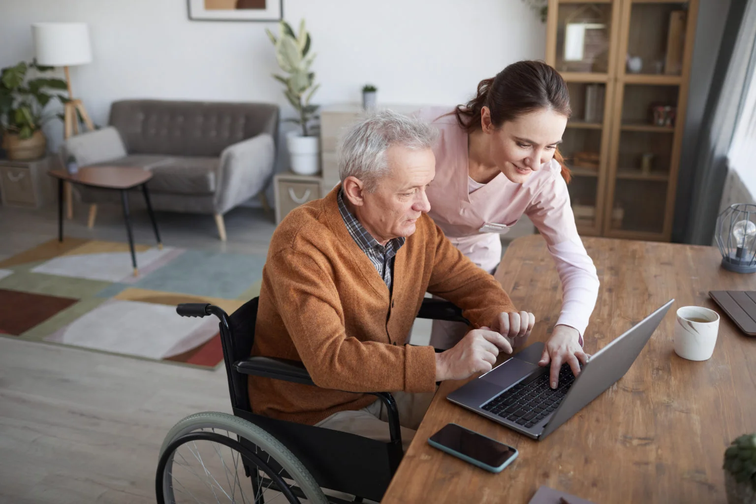 Portrait,Of,Senior,Man,In,Wheelchair,Using,Laptop,At,Retirement