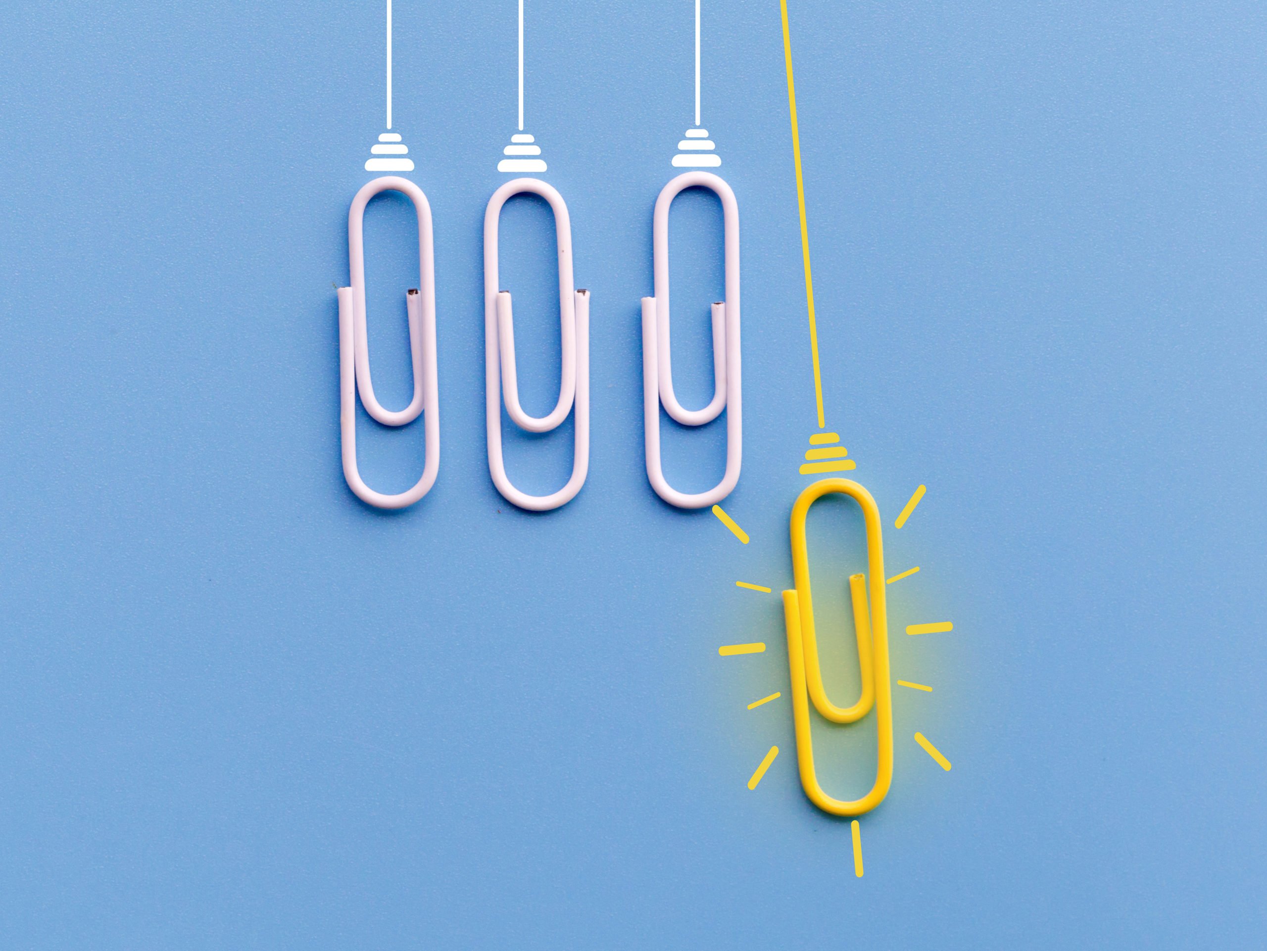 Great idea concept with a yellow and bright paper clip above other white paper clips in a line