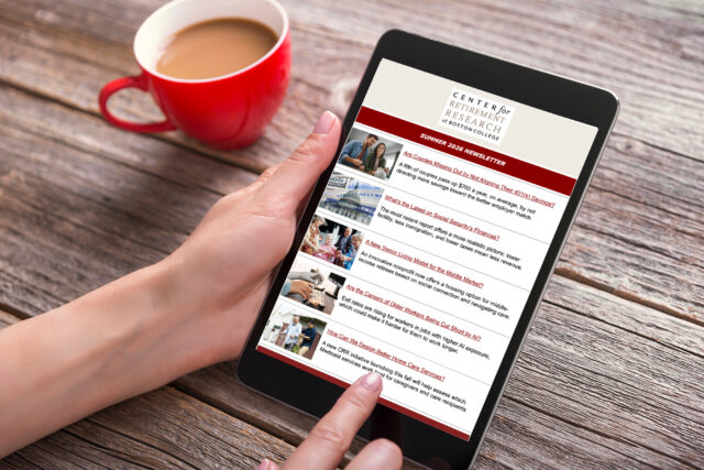 Digital tablet in female hands at a table with a red coffee cup